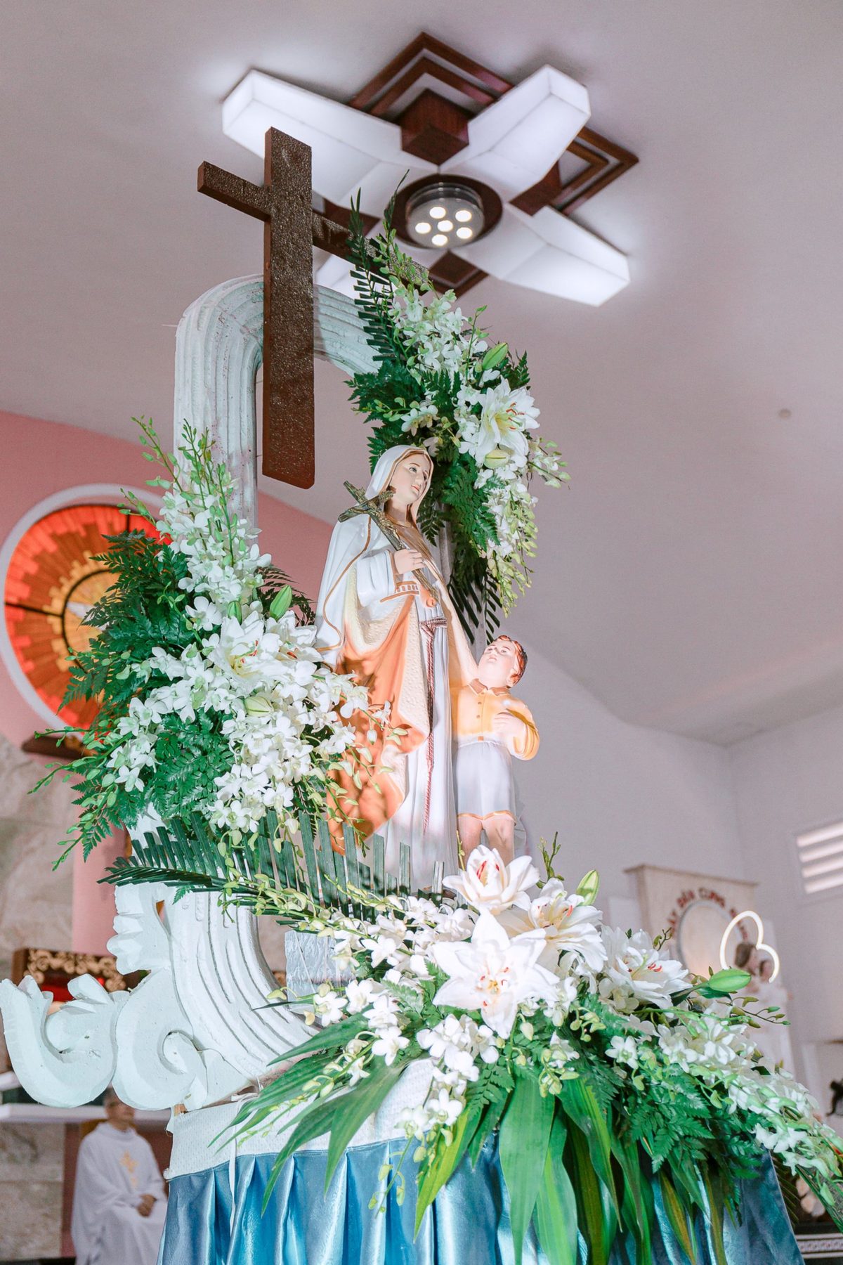 Andor de Nossa Senhora com cruz, decorado com lírios brancos, orquídeas brancas e feto, pela Florabella, florista em Fafe