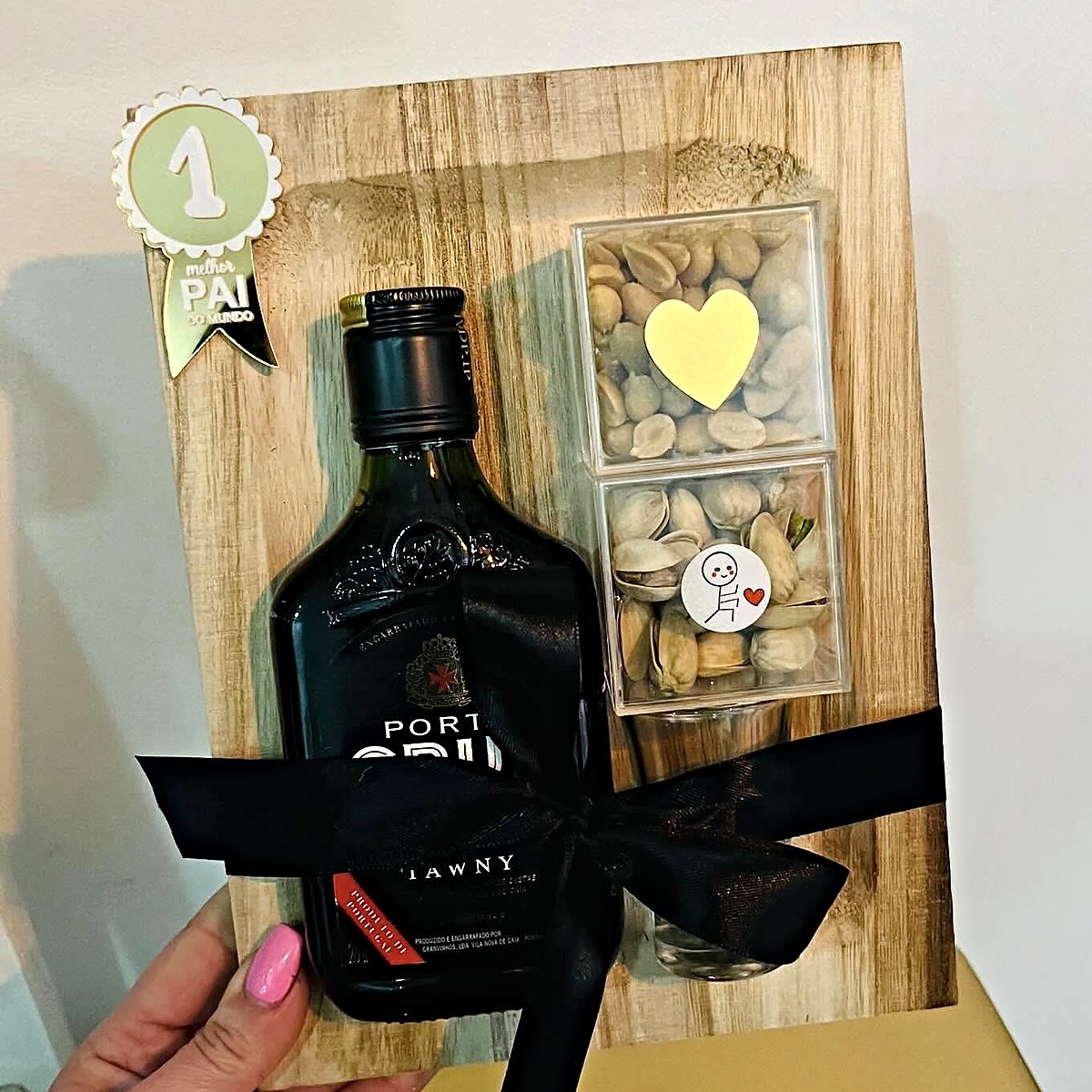 Prenda para o Dia do Pai numa tábua de madeira, com garrafa de vinho do Porto, frutos secos, copo e medalha de melhor pai do mundo, preparada pela Florabella em Fafe