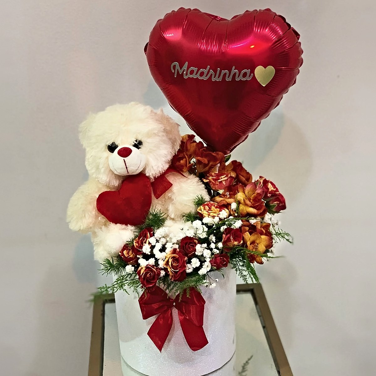 Prenda para a madrinha: caixa com rosas, gipsófila, peluche branco e balão em forma de coração com a palavra Madrinha, preparada pela Florabella em Fafe