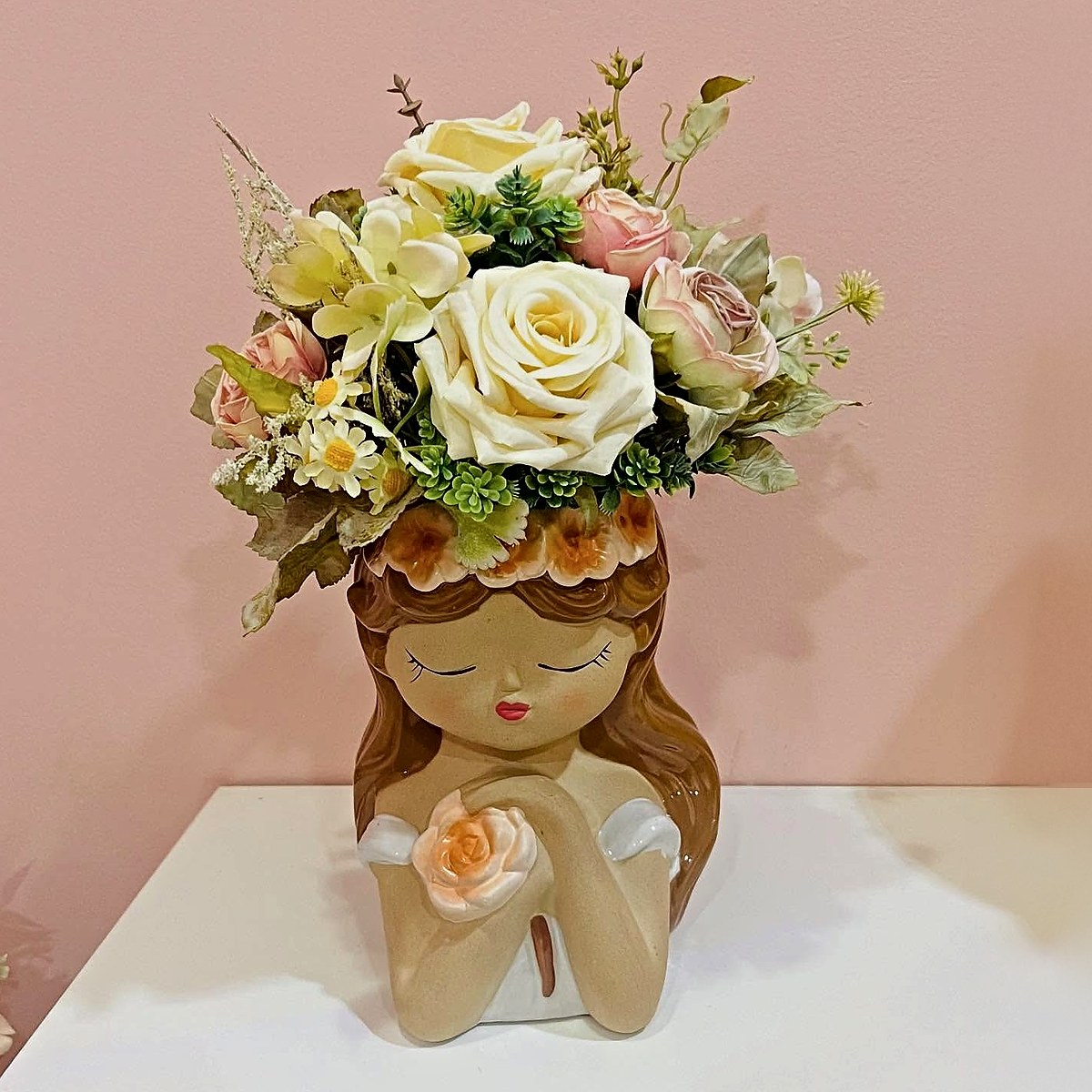 Vaso de cerâmica em forma de menina com arranjo de rosas creme e cor-de-rosa e margaridas, peça de decoração da Florabella em Fafe