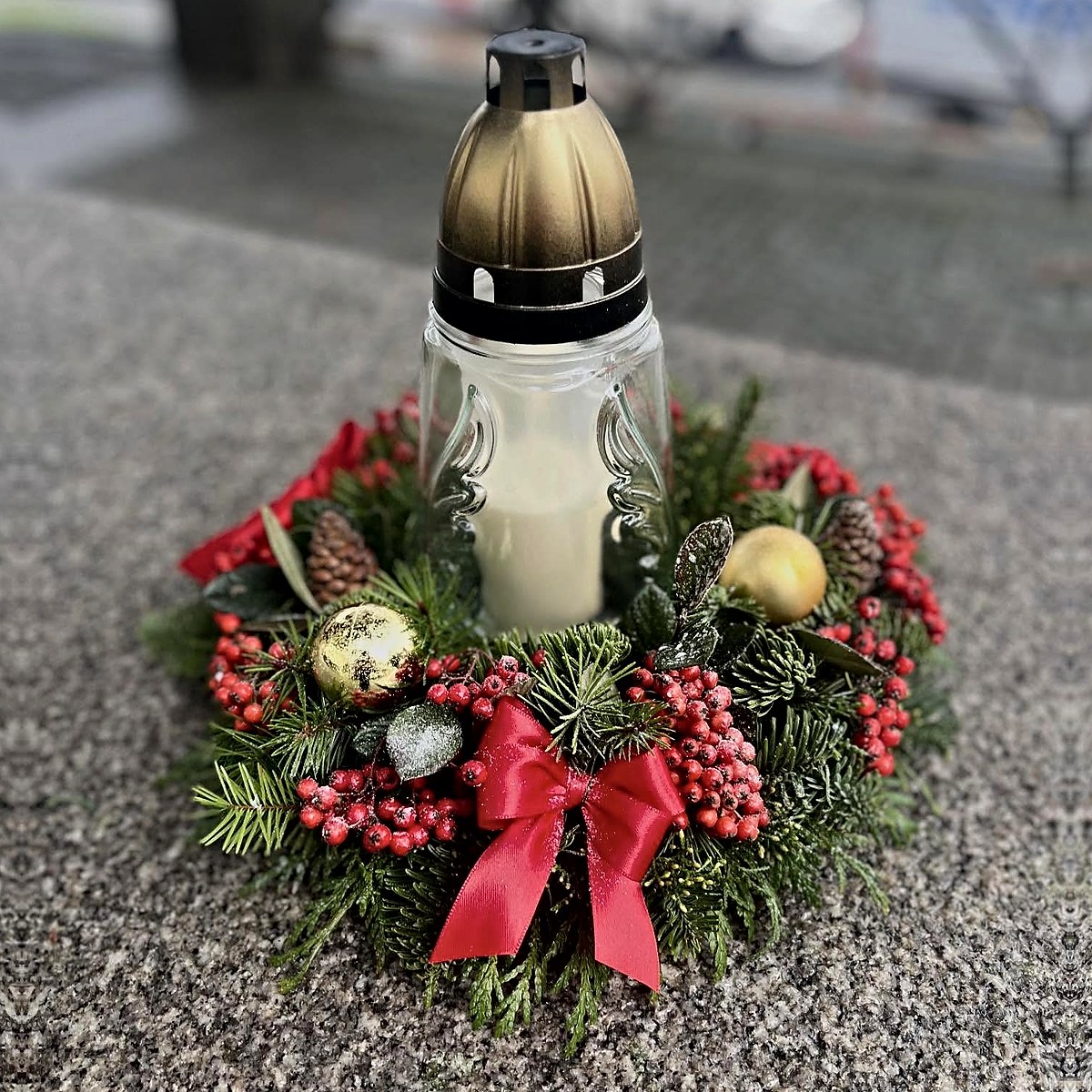 Vela de Natal para campa com coroa de pinheiro, bagas vermelhas, pinhas, bolas douradas e laço vermelho, feita pela Florabella em Fafe