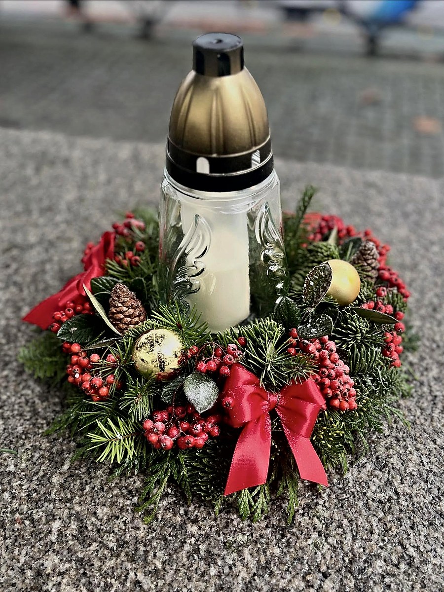 Vela de Natal para campa com coroa de pinheiro, bagas vermelhas, pinhas e laço vermelho, feita pela Florabella Florista em Fafe